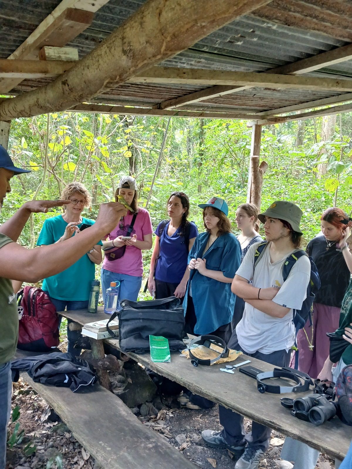 A group of visitors learning about bird banding from a local researcher at a forest station on Ometepe Island