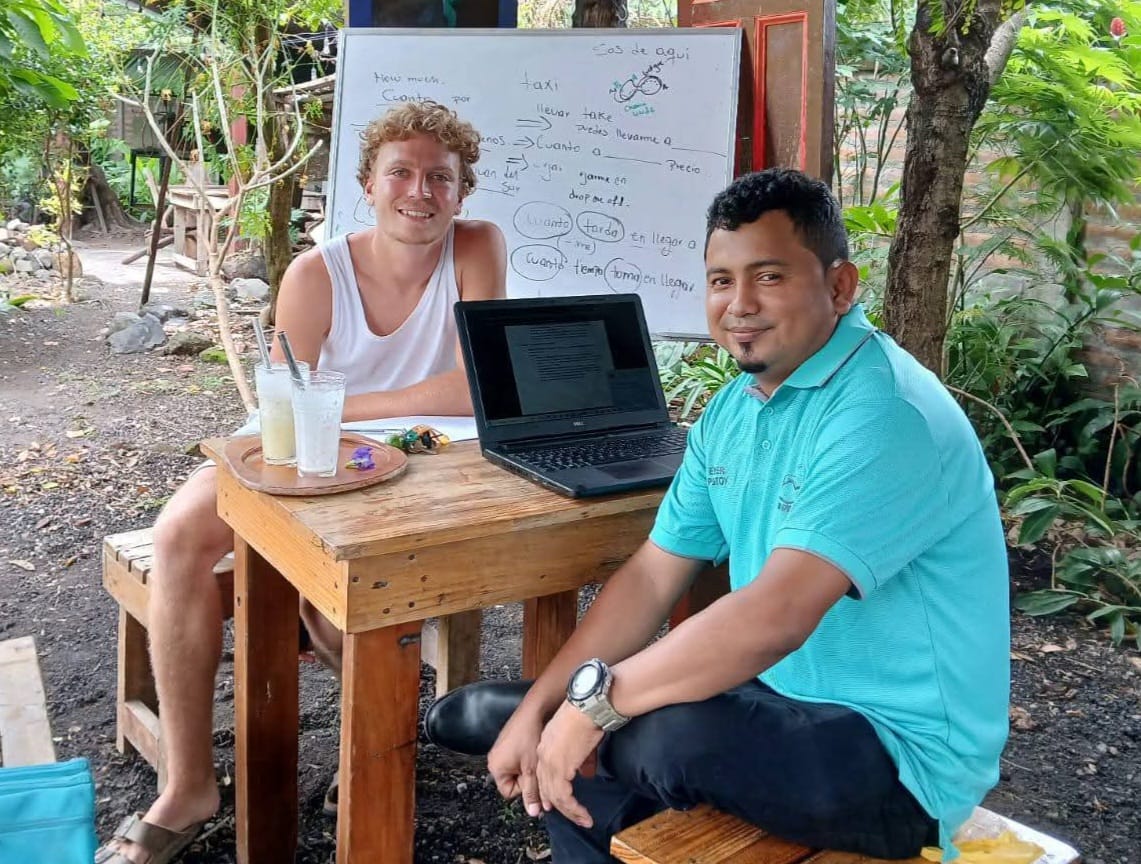 A community member teaching Spanish to visitors in Los Ramos